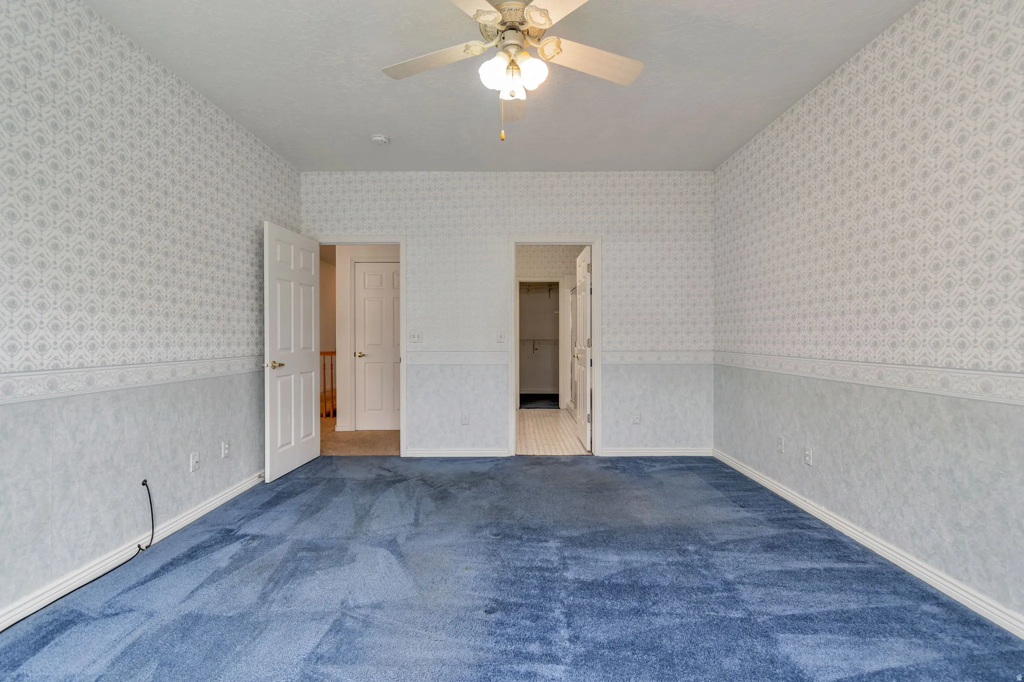 Unfurnished bedroom featuring a ceiling fan, carpet flooring, and a textured ceiling