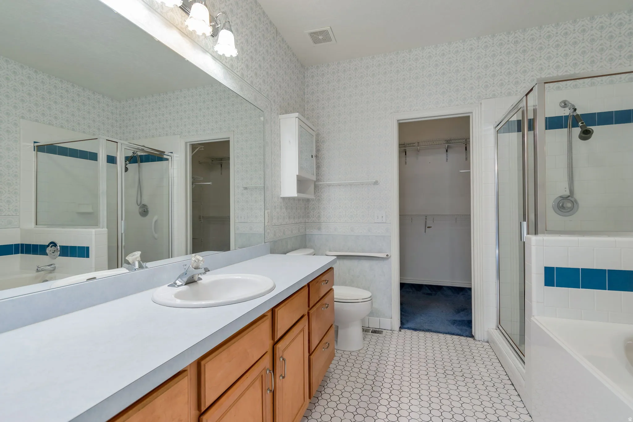 Full bath with a garden tub, a shower stall, wallpapered walls, vanity, and light tile patterned flooring