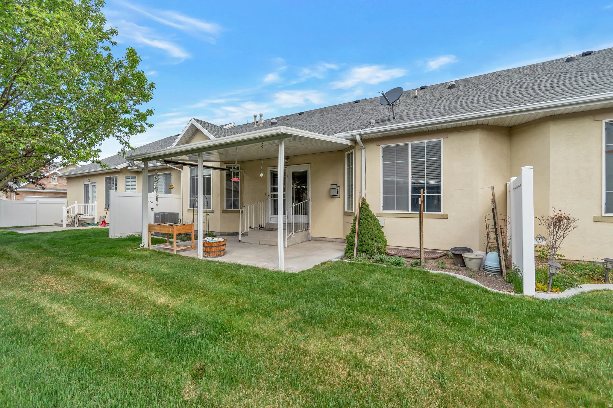 Back of property with stucco siding, a patio, and a shingled roof