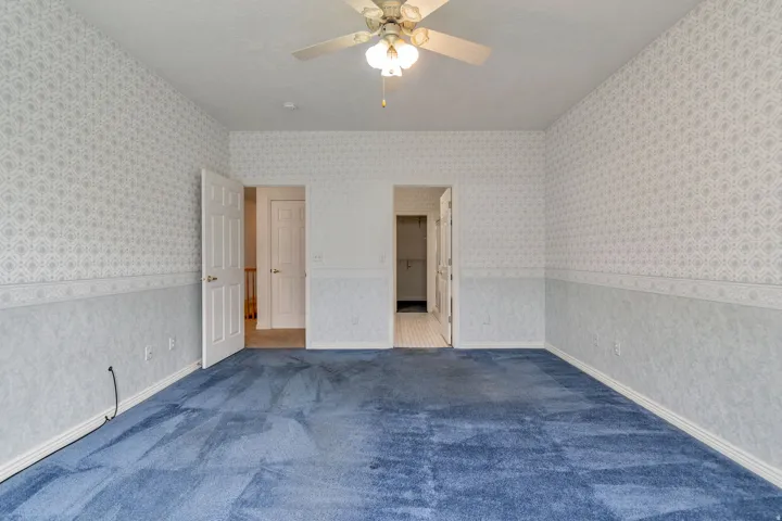Unfurnished bedroom featuring a ceiling fan, carpet flooring, and a textured ceiling