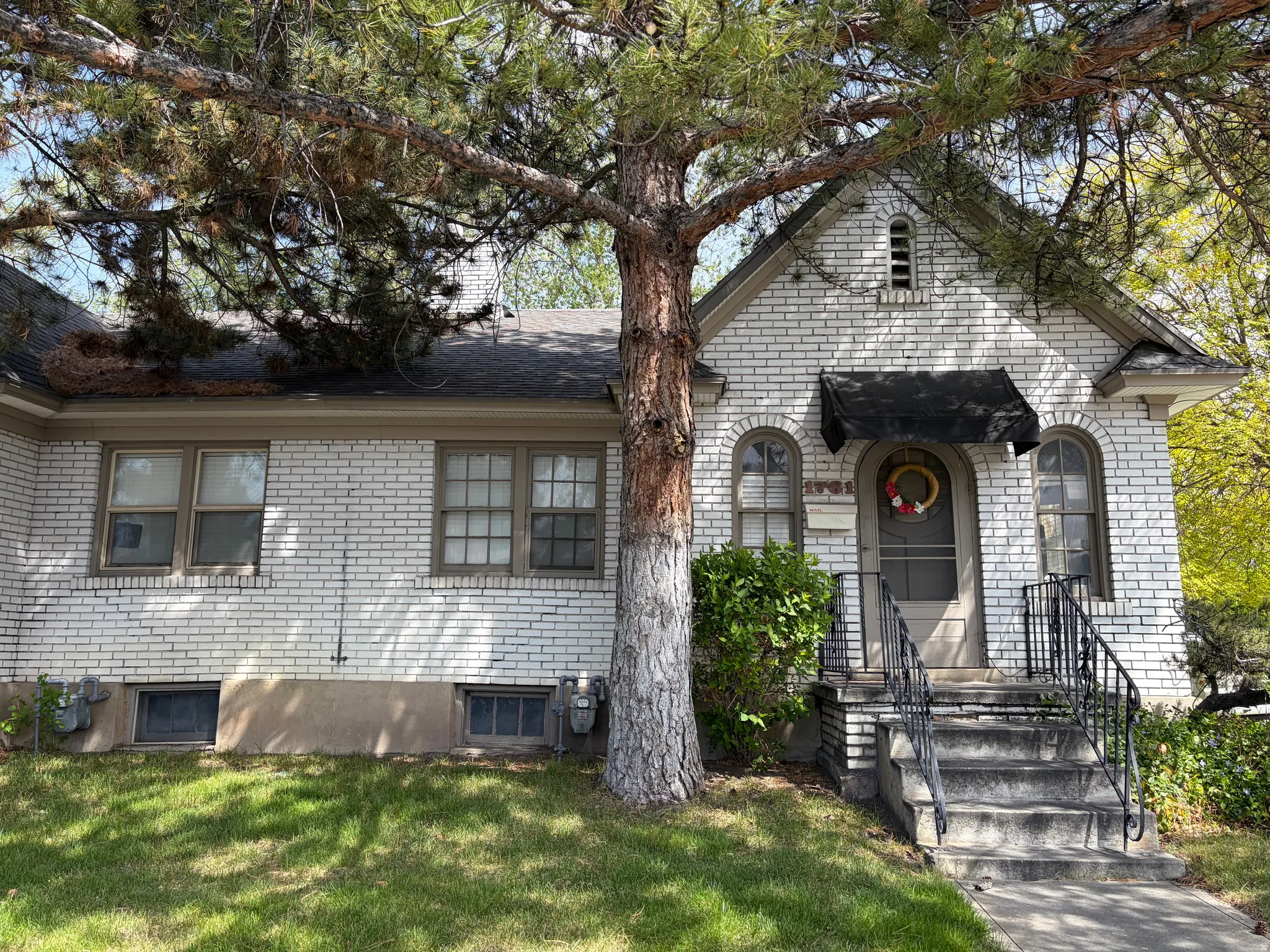 View of front of property featuring brick siding and a front lawn