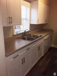 Kitchen featuring white cabinets, white dishwasher, and dark wood-style floors