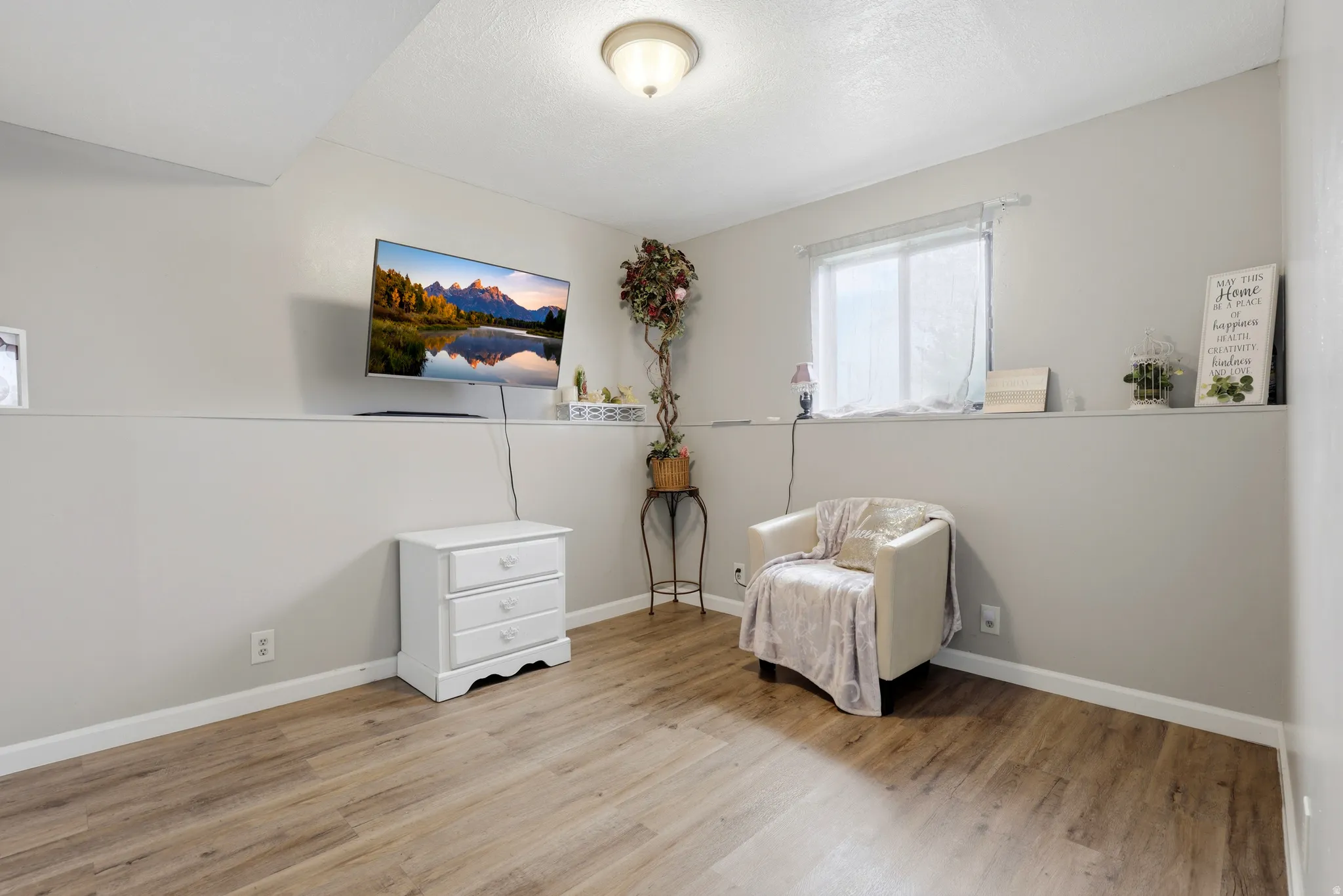 Living area featuring light wood-type flooring and baseboards