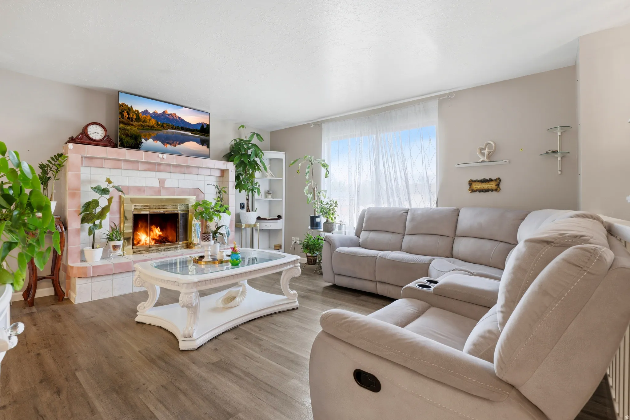 Living room with wood finished floors and a tiled fireplace