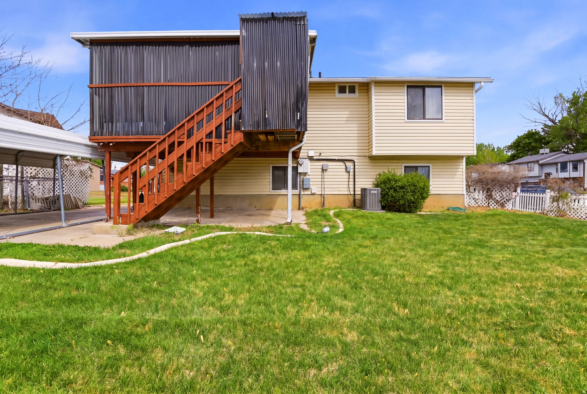 Rear view of property featuring a deck and a patio