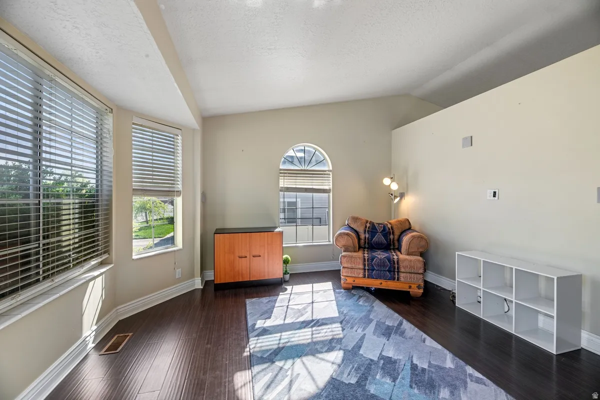 Living area with baseboards and dark wood-style flooring