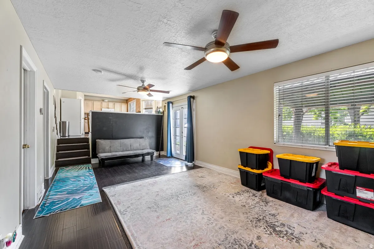 Interior space featuring a textured ceiling, dark wood-type flooring, and a ceiling fan