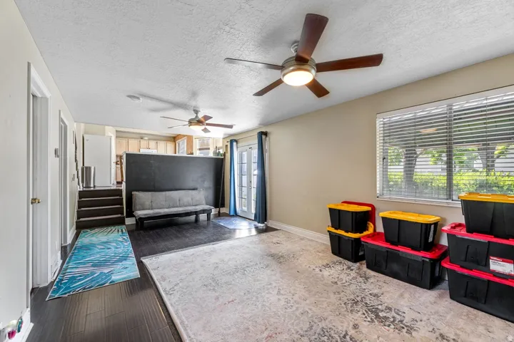 Interior space featuring a textured ceiling, dark wood-type flooring, and a ceiling fan