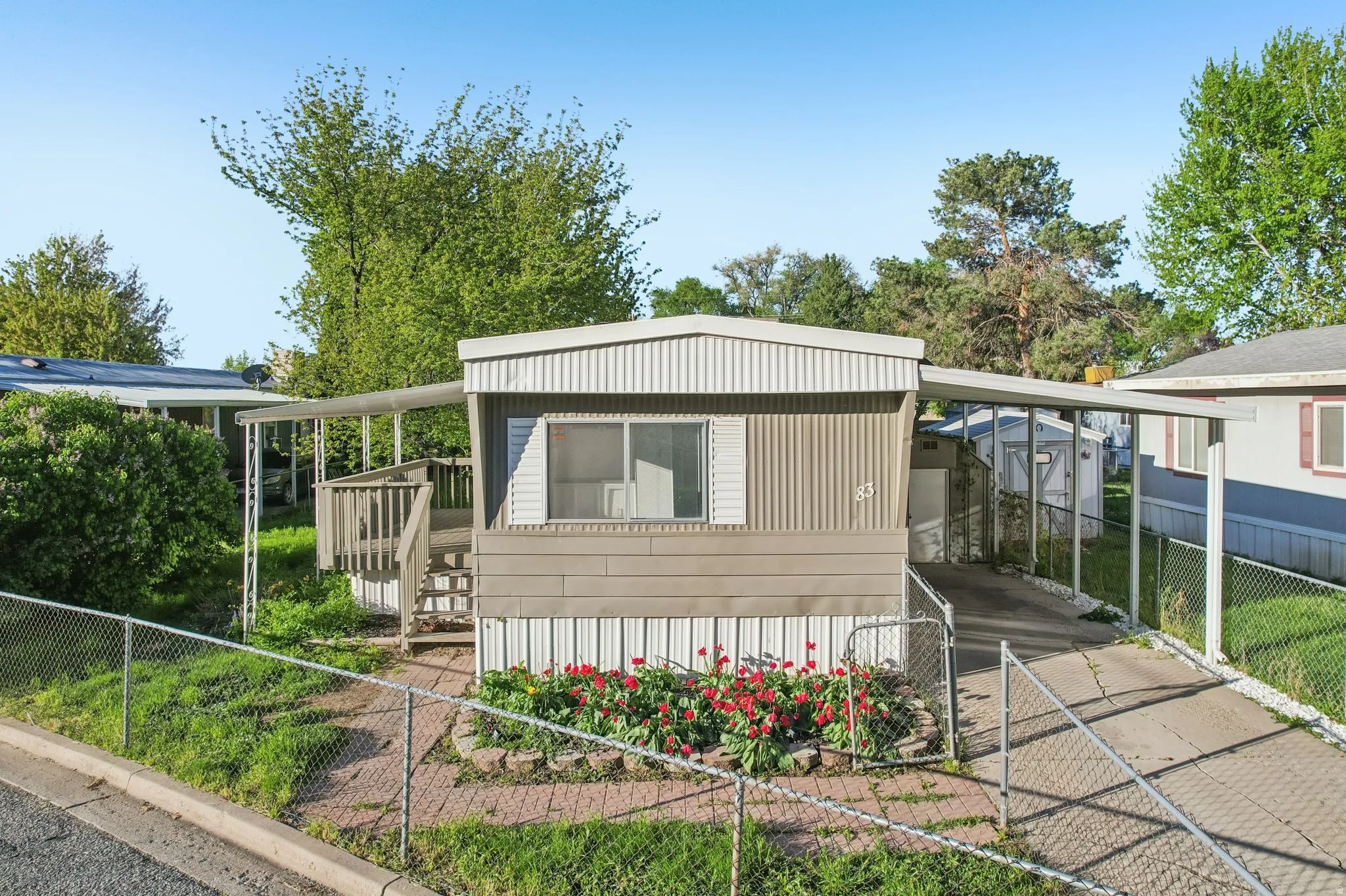 View of front facade with a carport and a fenced front yard