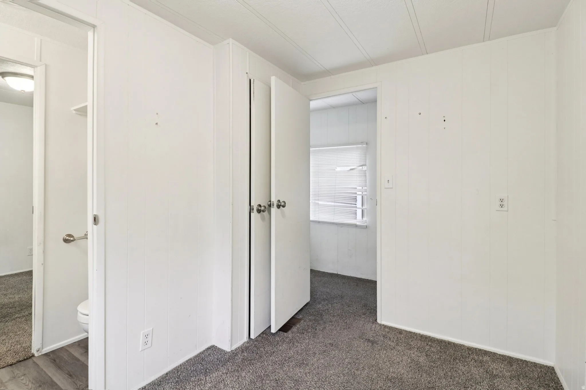 Hallway with dark carpet and wooden walls