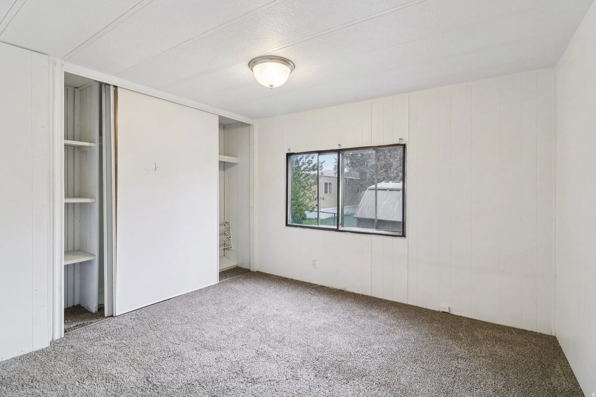 Unfurnished bedroom with carpet and wood walls
