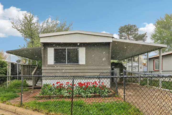 View of front of house with a storage unit and an attached carport
