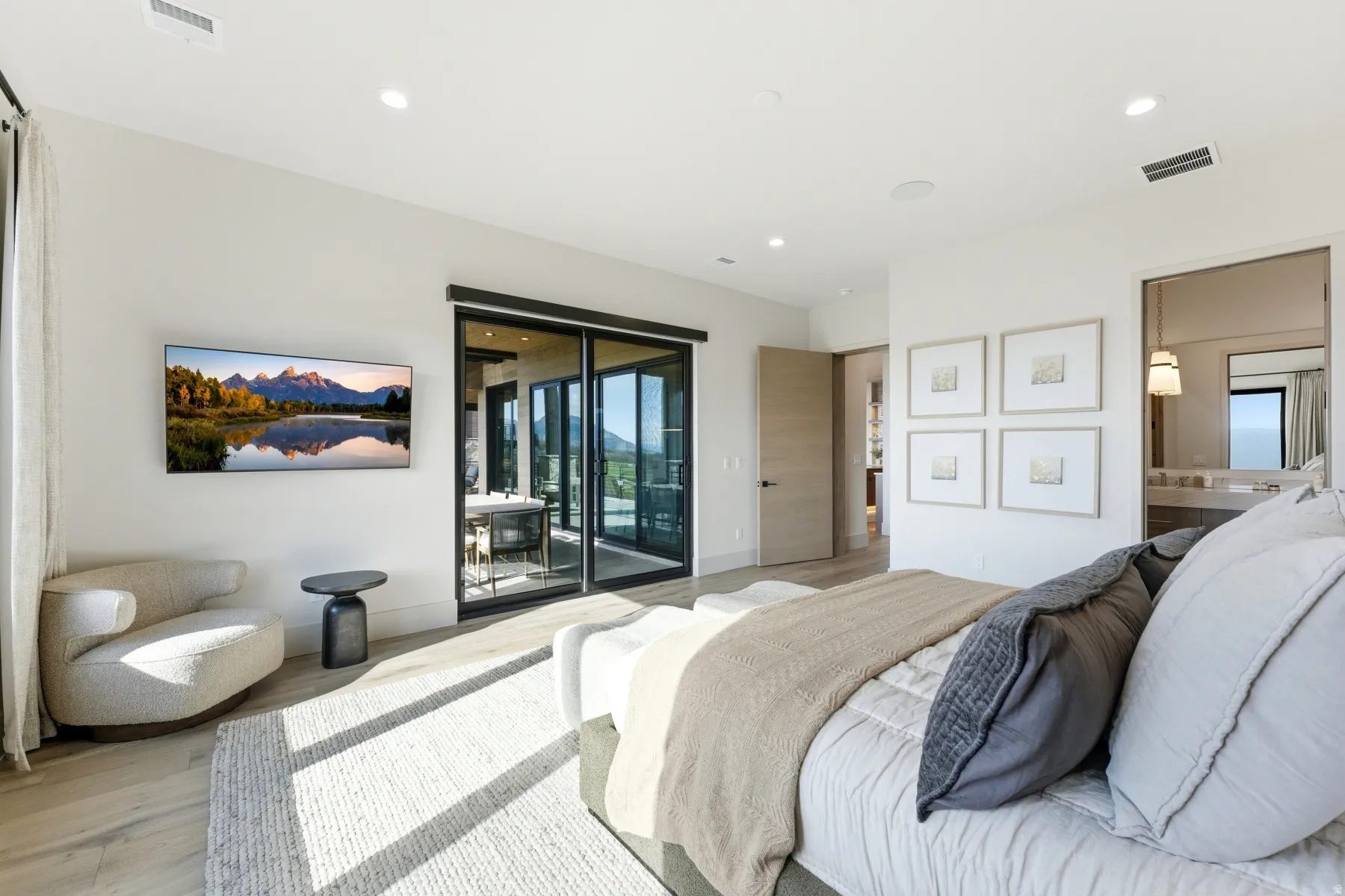 Bedroom featuring light wood-style floors, access to exterior, recessed lighting, and ensuite bath