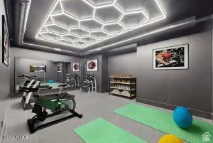 Dedicated fitness space with hexagonal recessed lighting, large wall mirror, exposed ductwork, and grey wall finish