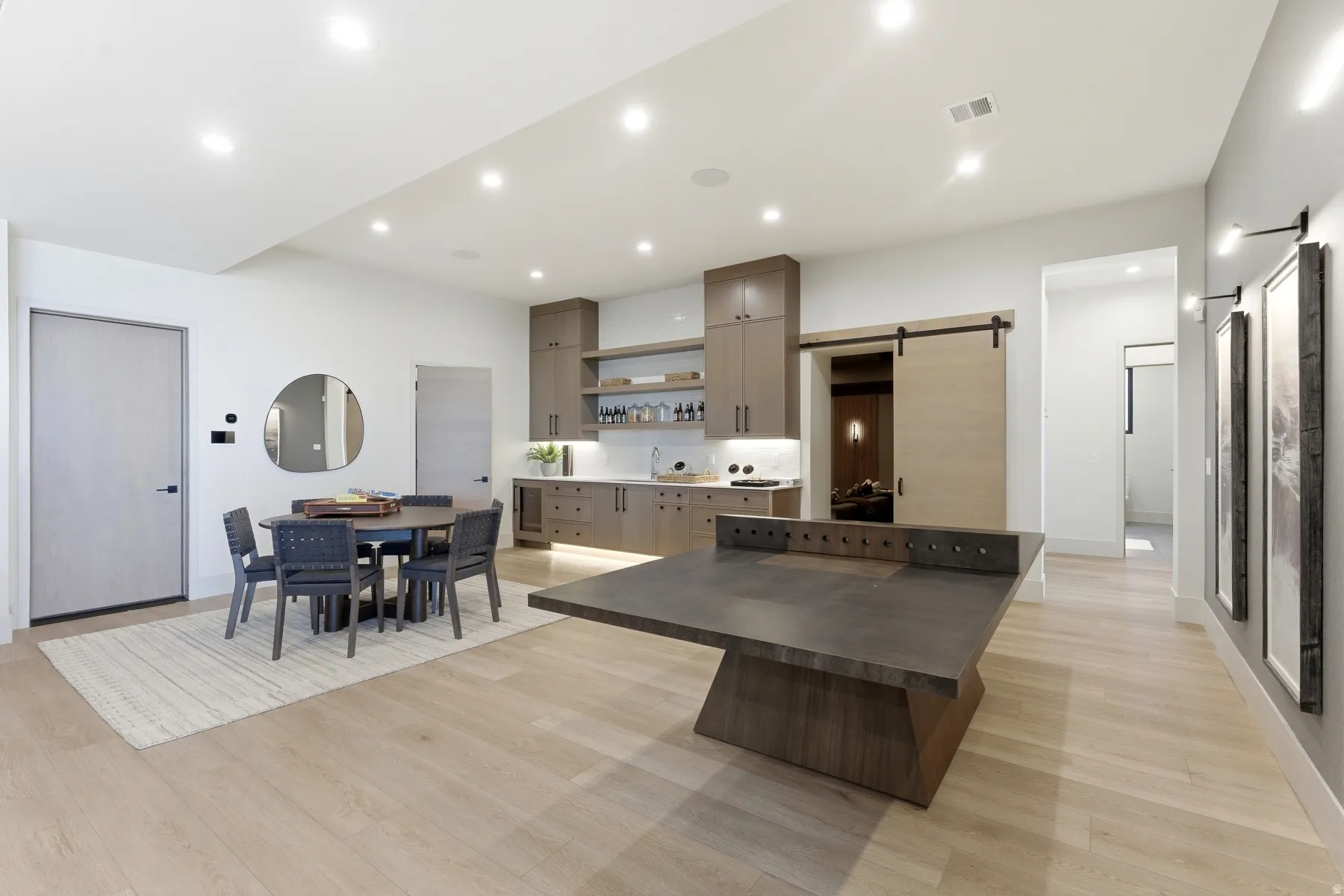 Kitchen with a barn door, light wood-type flooring, a center island, open shelves, and recessed lighting