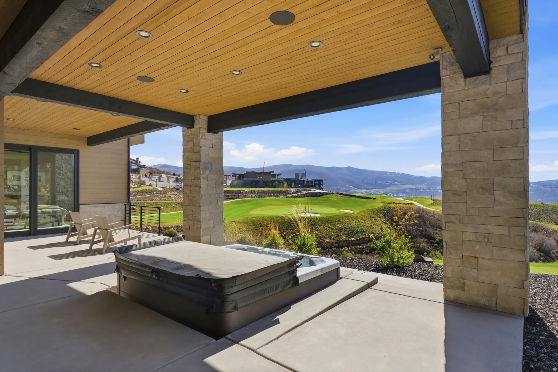 View of patio / terrace with a mountain view, a hot tub, and golf course view