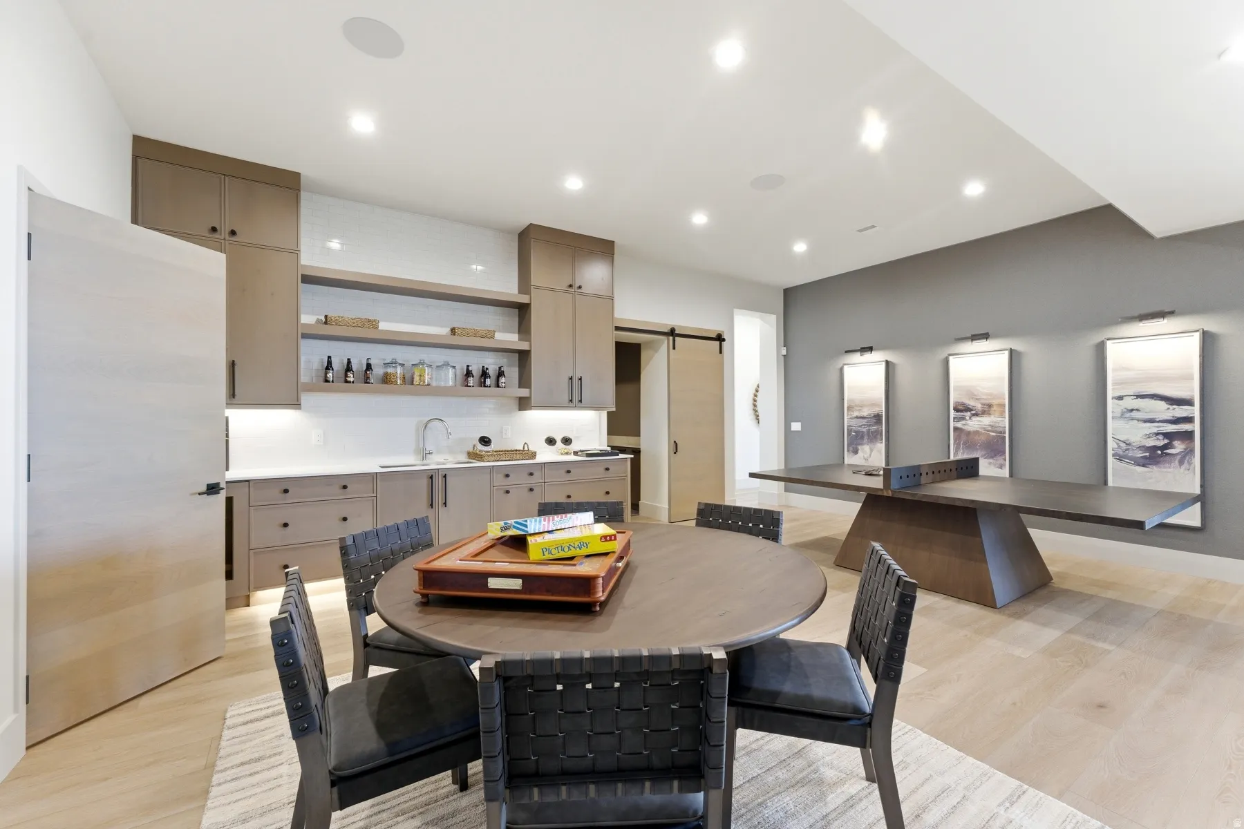 Dining space featuring a barn door, light wood-style flooring, and recessed lighting