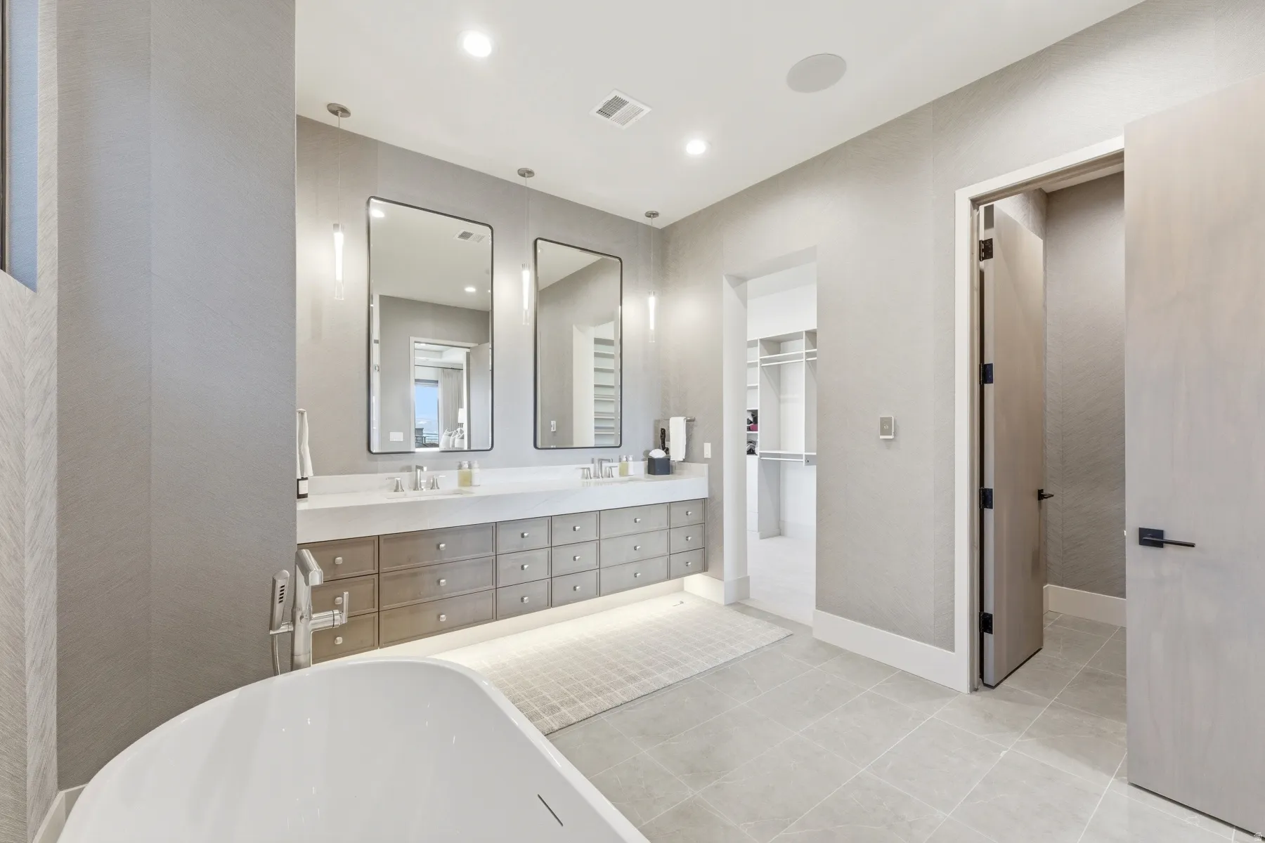 Bathroom with a soaking tub, double vanity, light tile patterned flooring, and recessed lighting