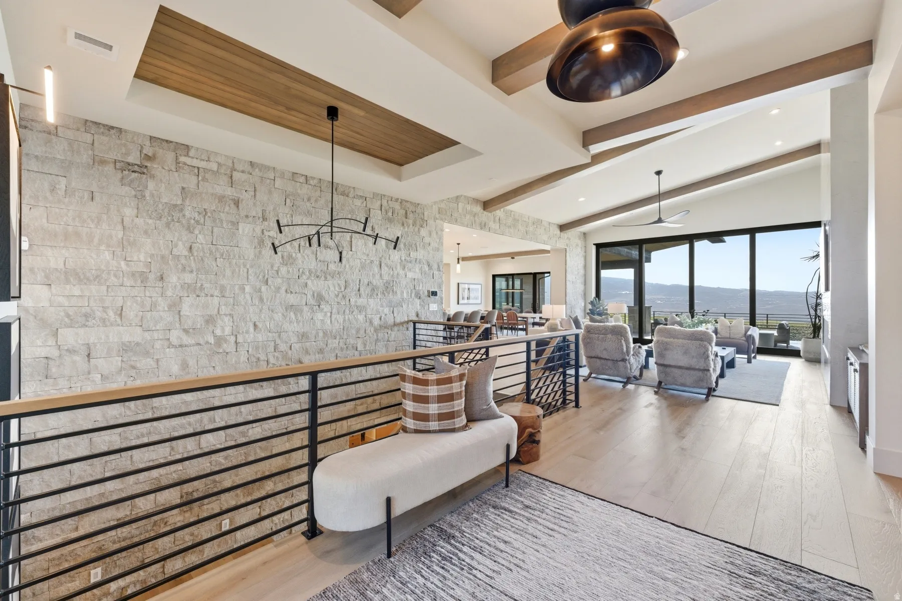 Living room featuring light wood-type flooring, a mountain view, ceiling fan, and lofted ceiling with beams