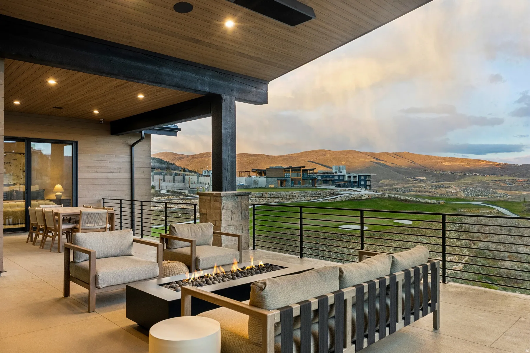View of patio with a mountain view, an outdoor living space with a fire pit, and ceiling fan