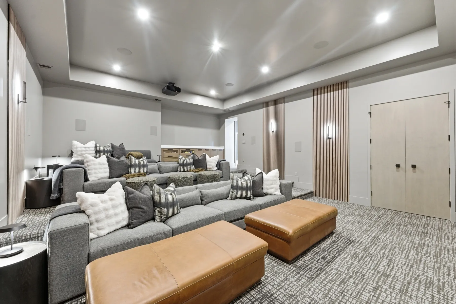Carpeted home theater room featuring a tray ceiling and recessed lighting