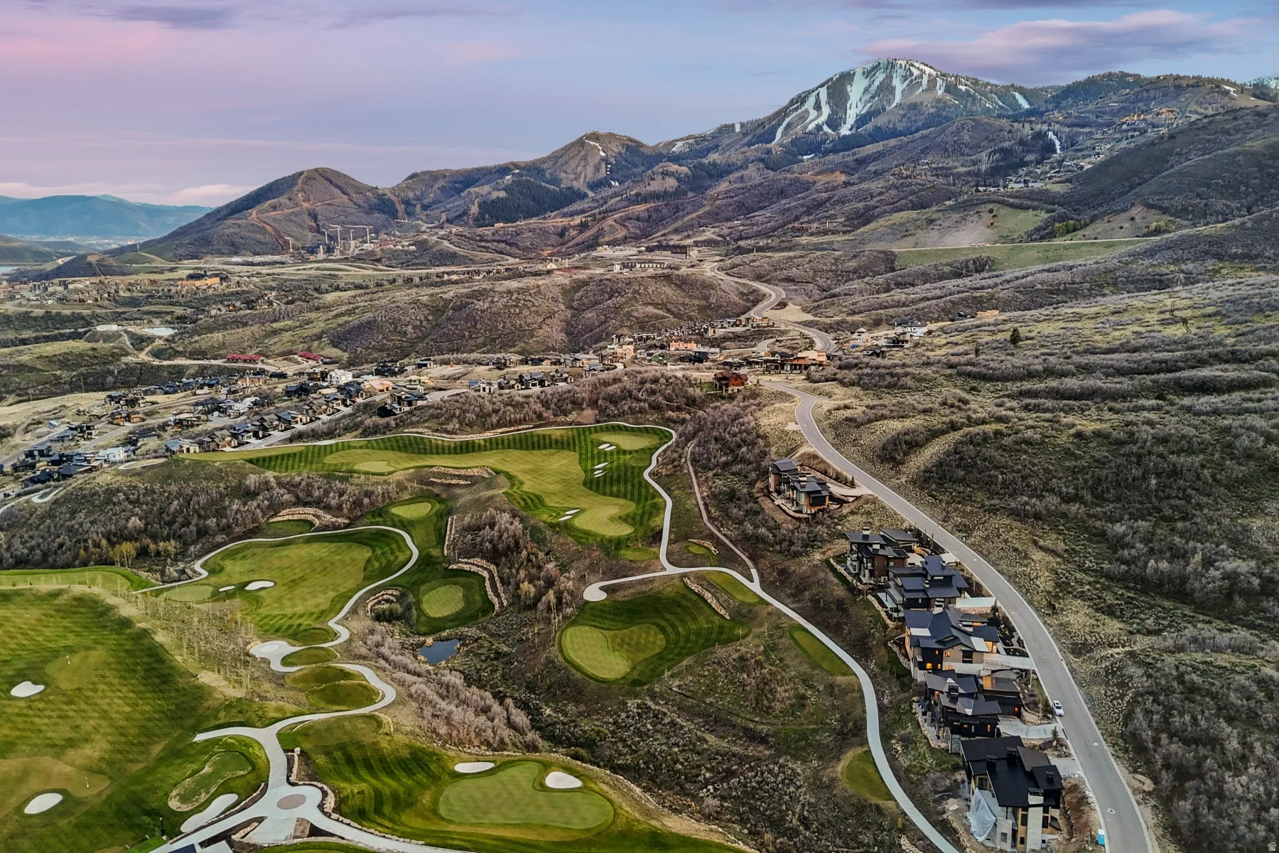 Bird's eye view of a mountainous background and a local golf course