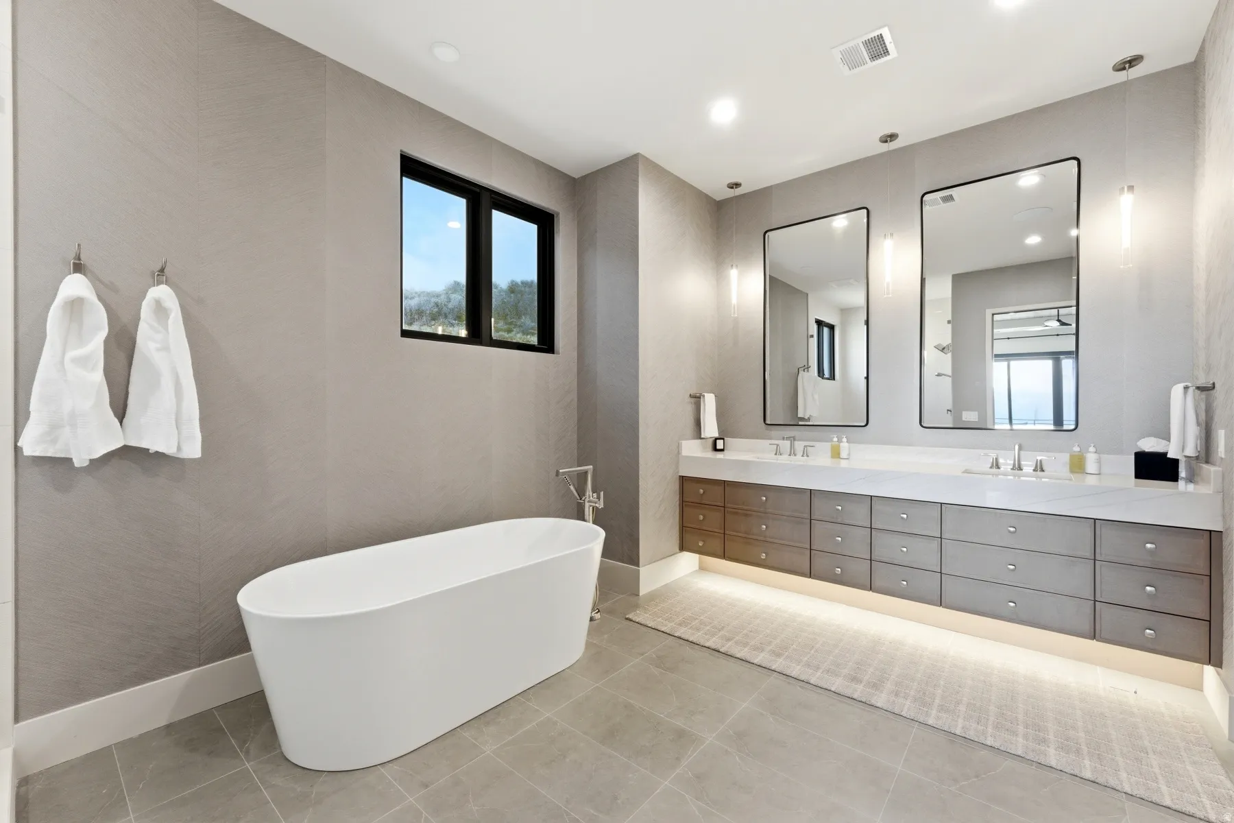 Bathroom with a freestanding tub, double vanity, and recessed lighting