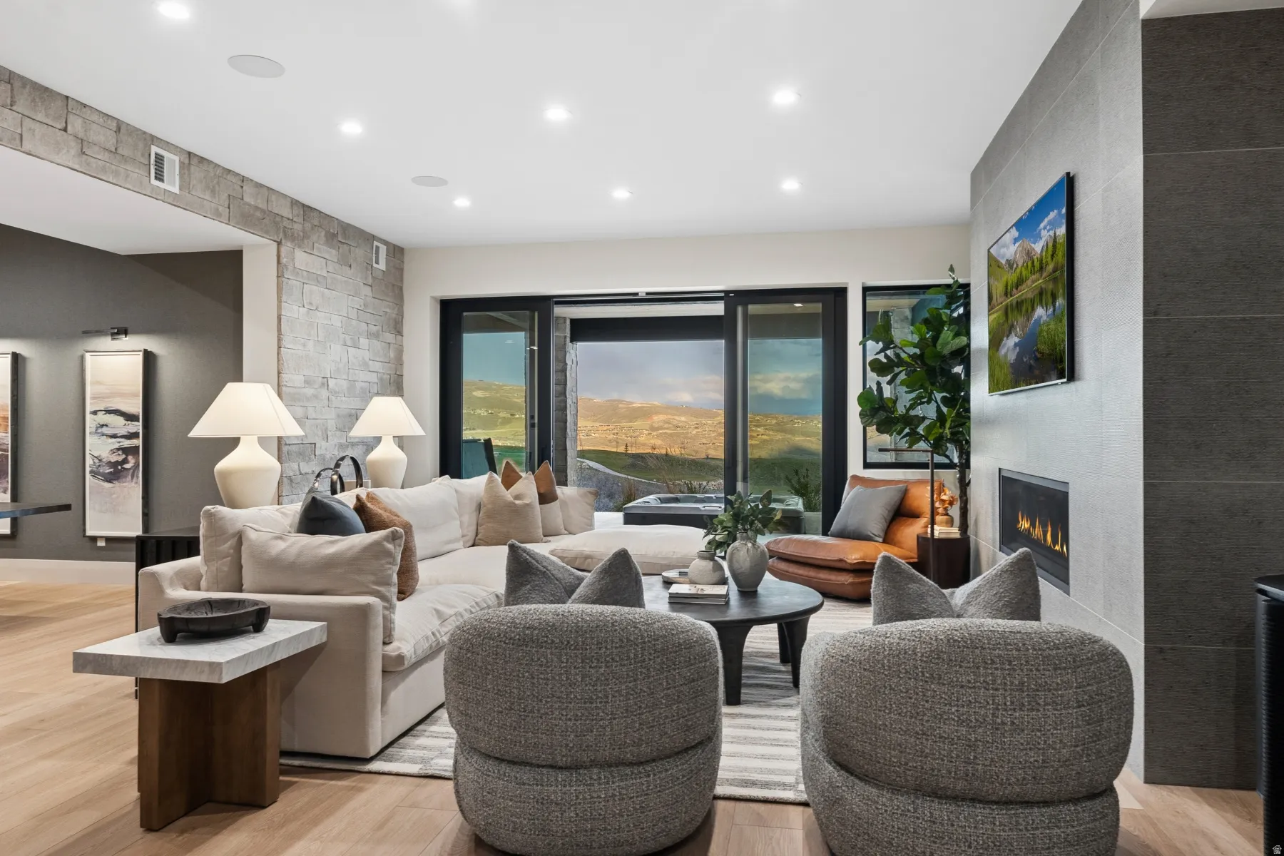 Living area with light wood finished floors, a large fireplace, and recessed lighting