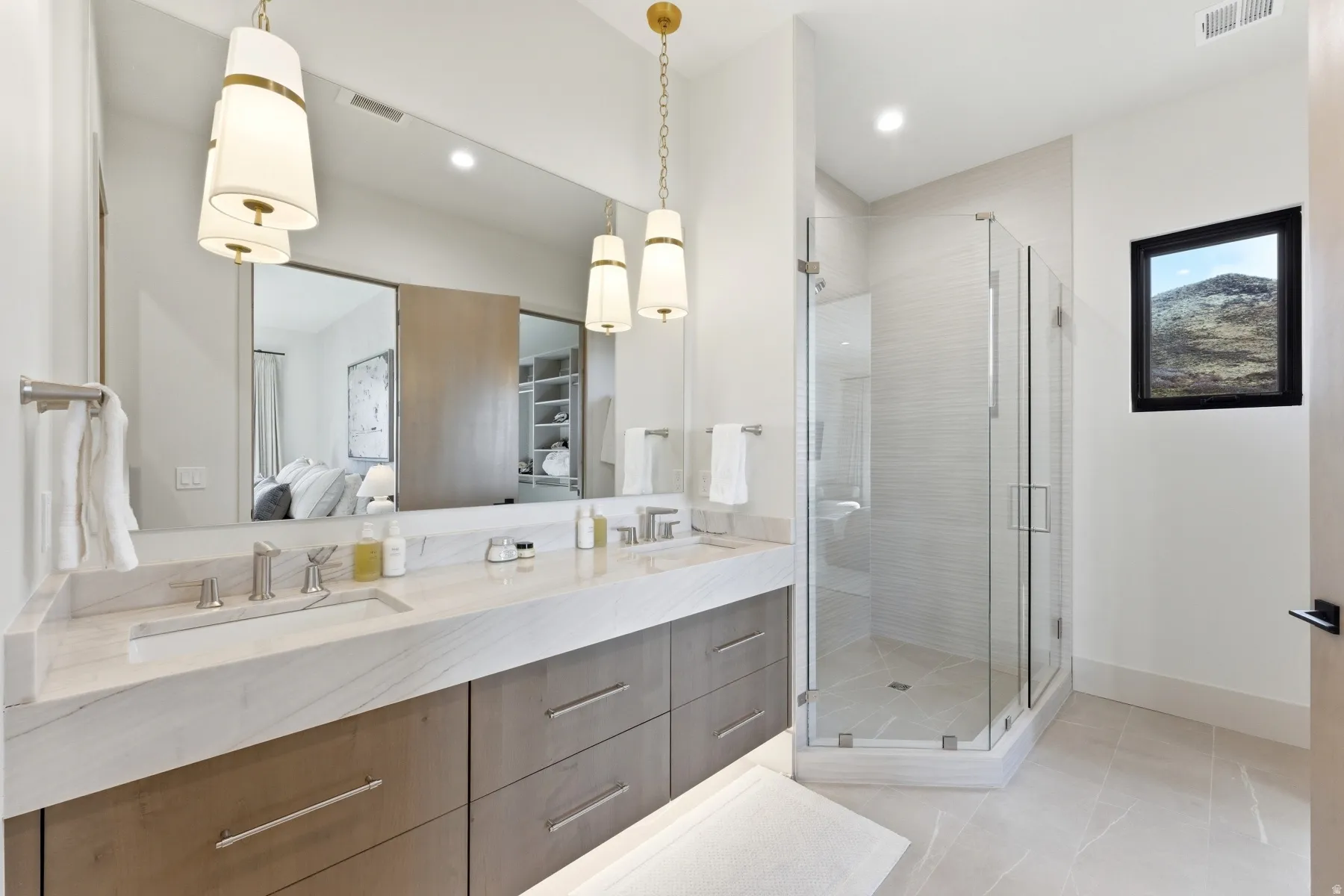 Bathroom featuring double vanity, a stall shower, ensuite bathroom, and light tile patterned floors