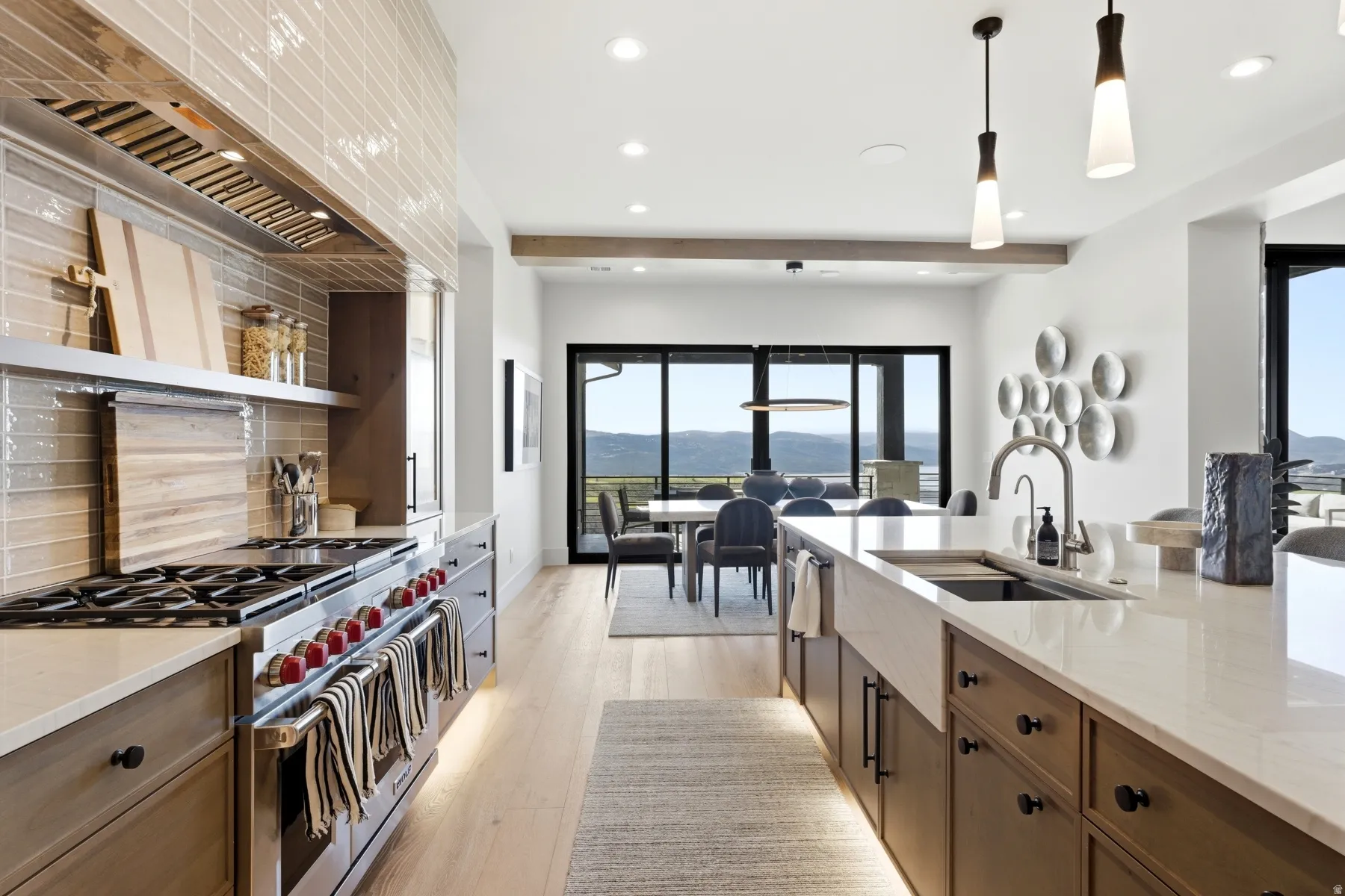 Kitchen featuring light stone counters, range with two ovens, a mountain view, and light wood-style flooring