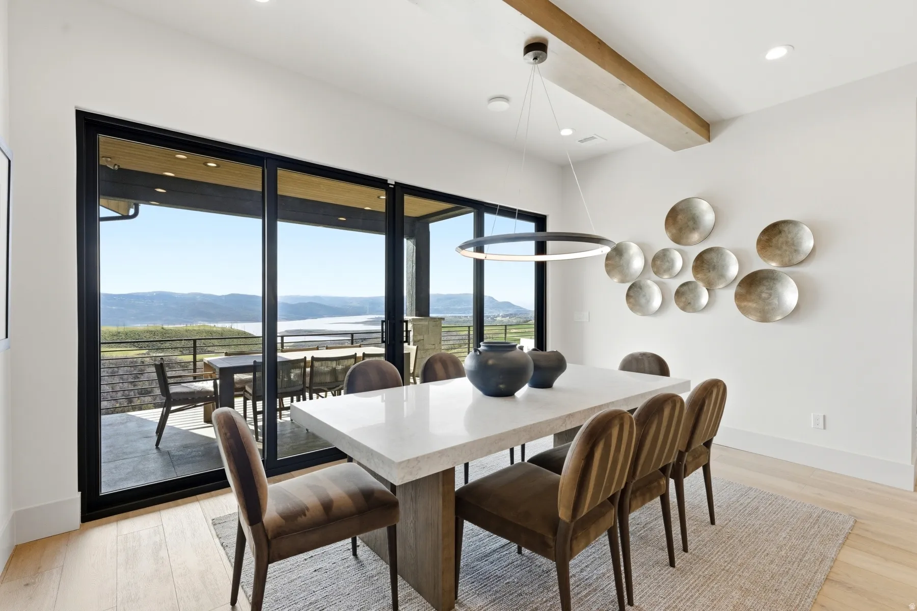 Dining area with a mountain view, beam ceiling, light wood-type flooring, and recessed lighting
