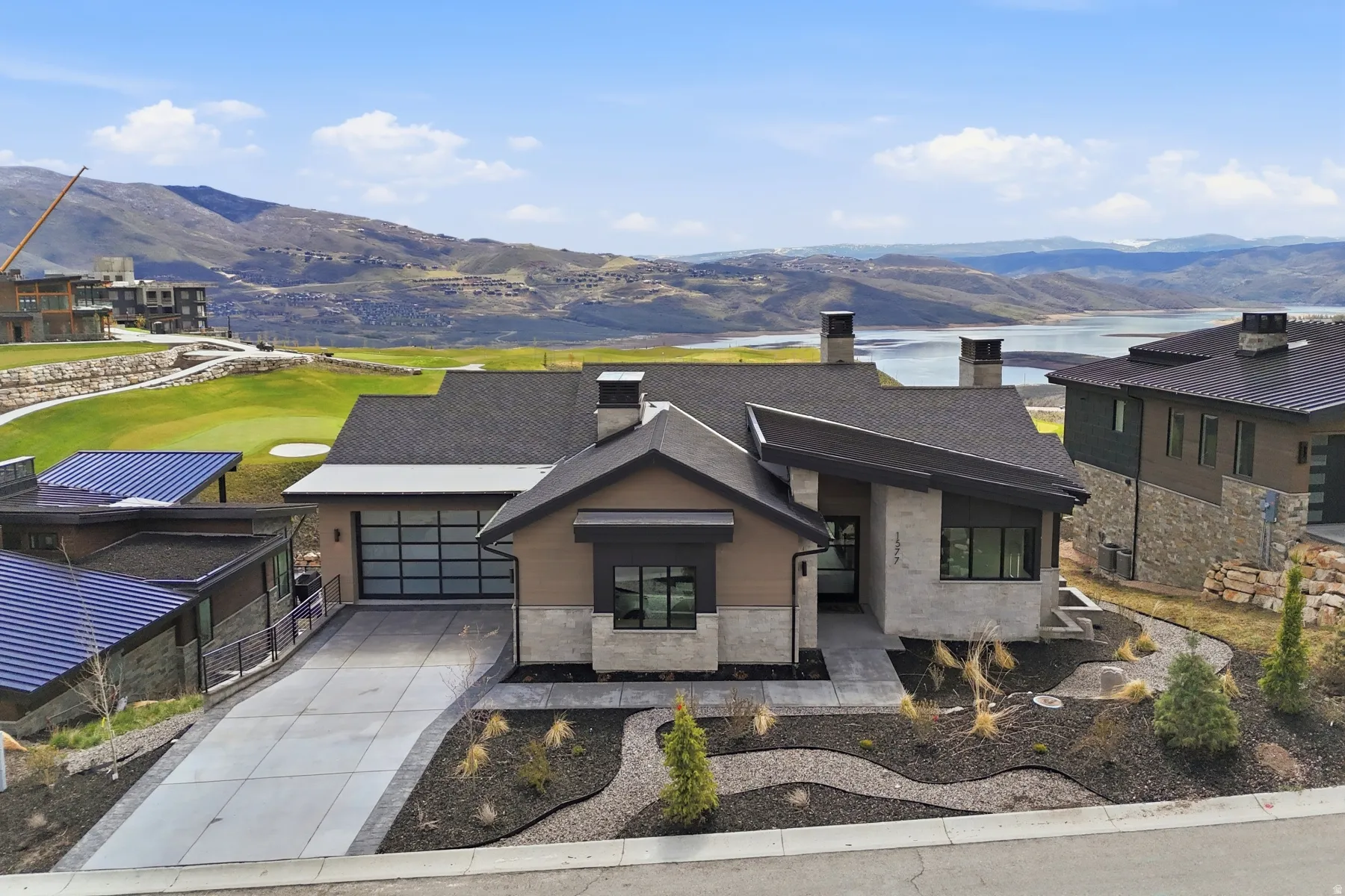 Contemporary home featuring a chimney, a mountain view, driveway, stucco siding, and stone siding
