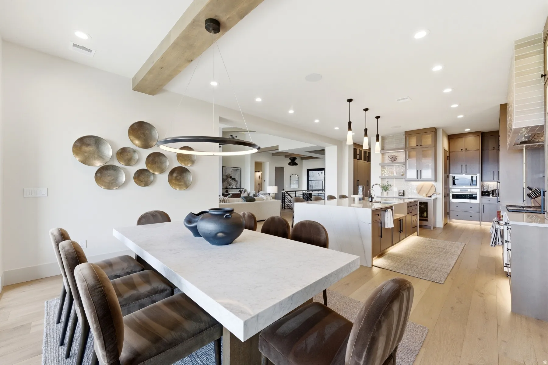 Dining room with light wood finished floors, recessed lighting, and beamed ceiling