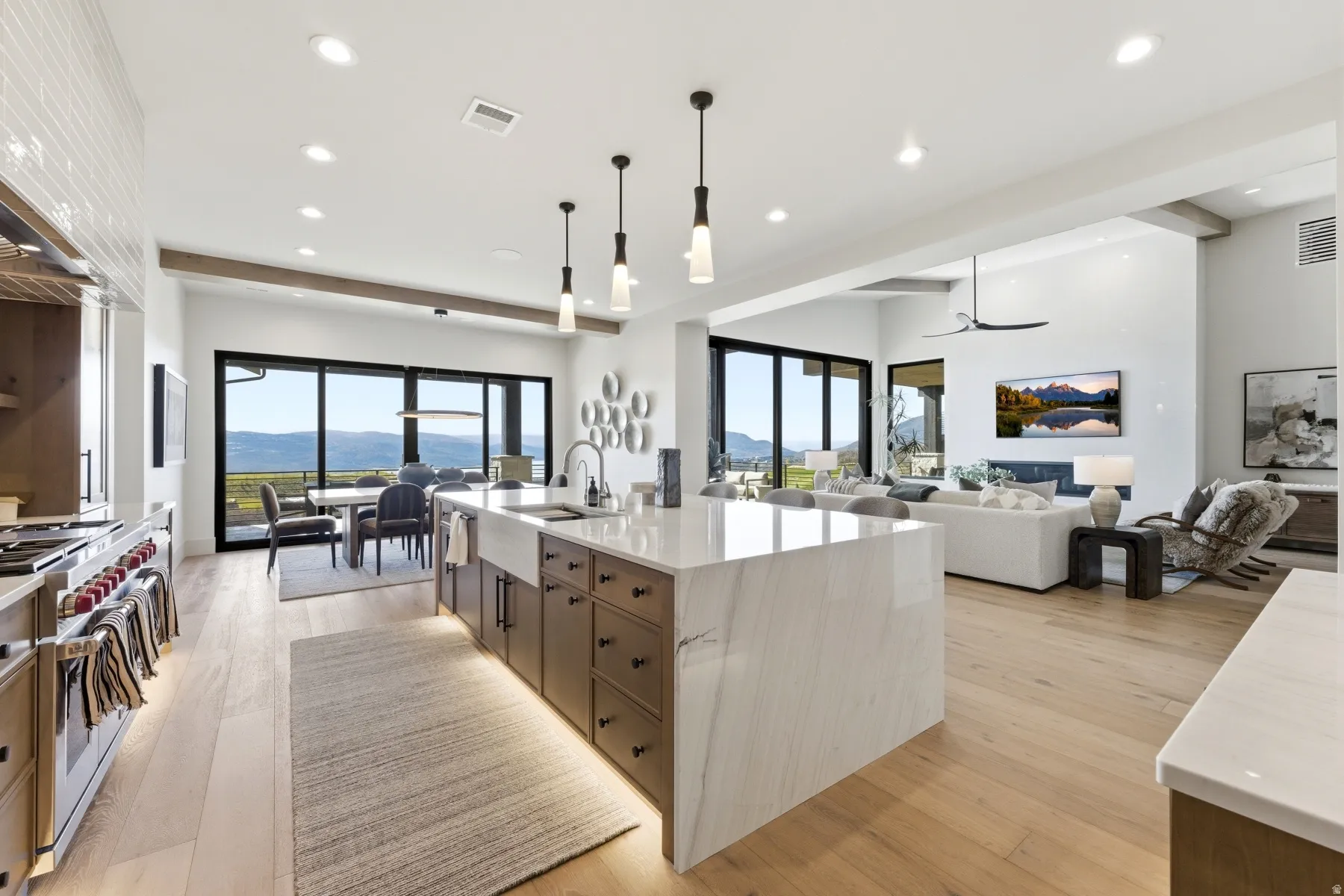 Kitchen featuring open floor plan, a mountain view, light wood finished floors, and light stone counters