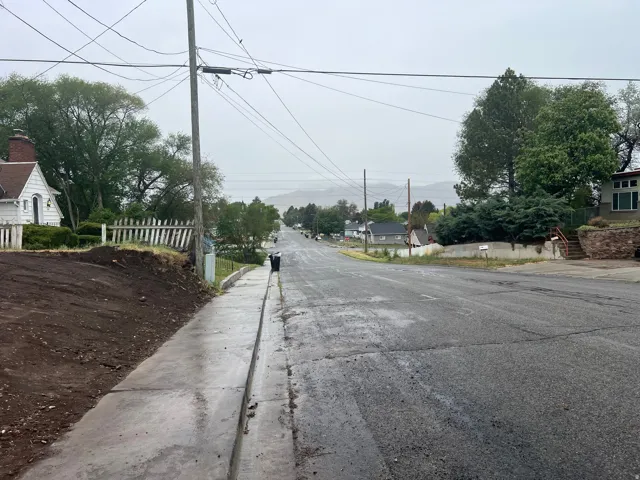 View of asphalt street featuring sidewalks, curbs, and a residential view