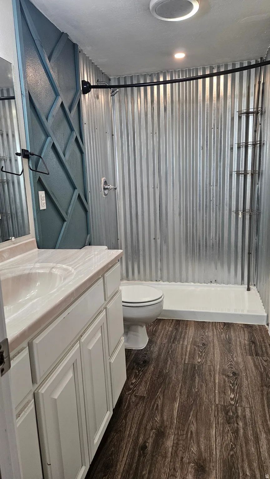 Full bath with vanity, dark wood finished floors, shower / bath combo with shower curtain, and a textured ceiling