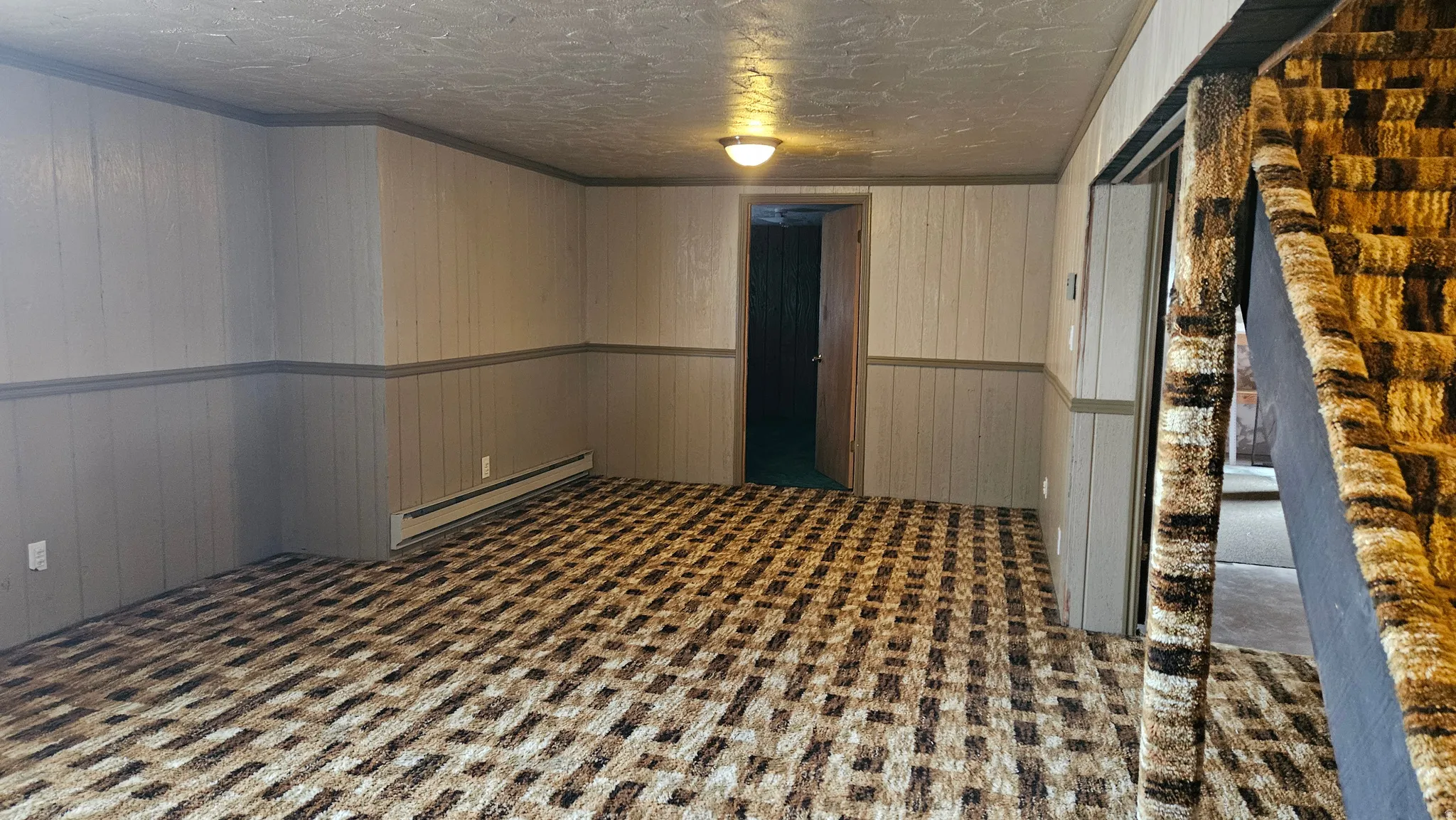 Spare room with a baseboard radiator and wooden walls
