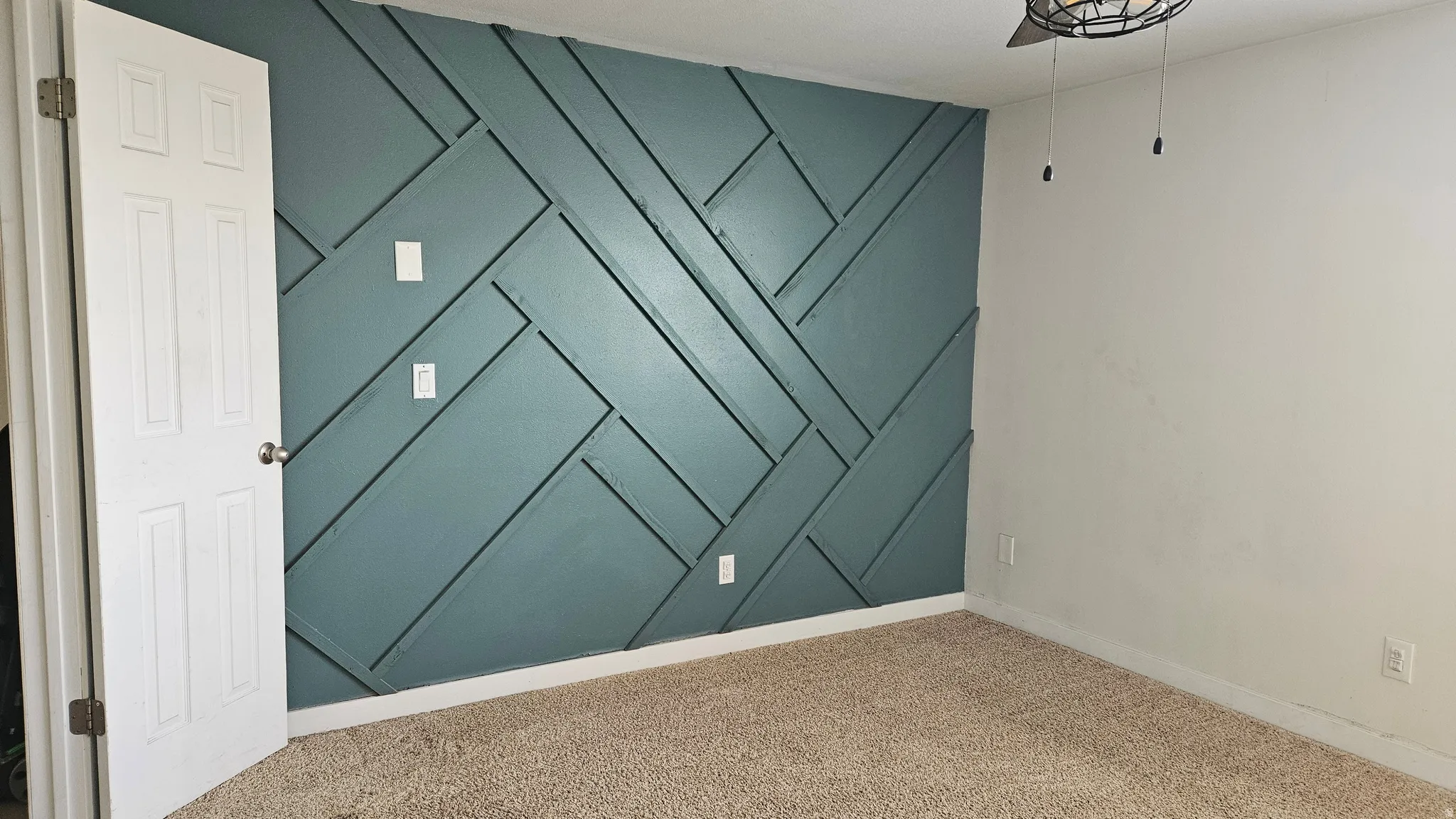 Carpeted empty room with a decorative wall