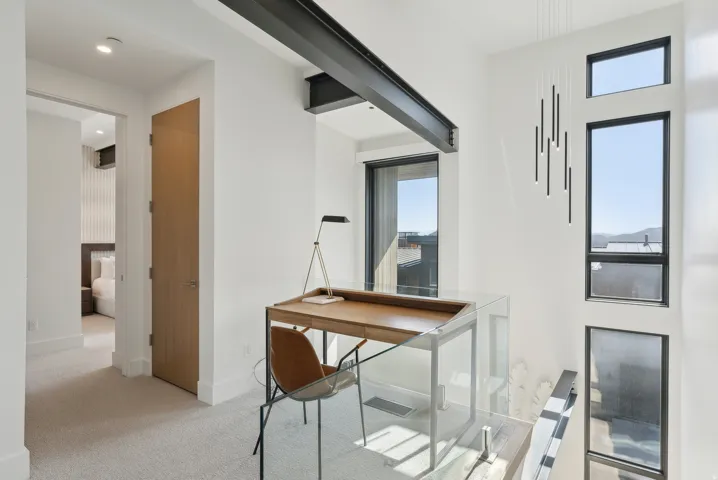 Home office with light carpet and baseboards