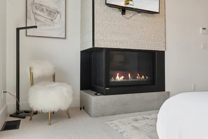 Detailed view of carpet flooring and a glass covered fireplace