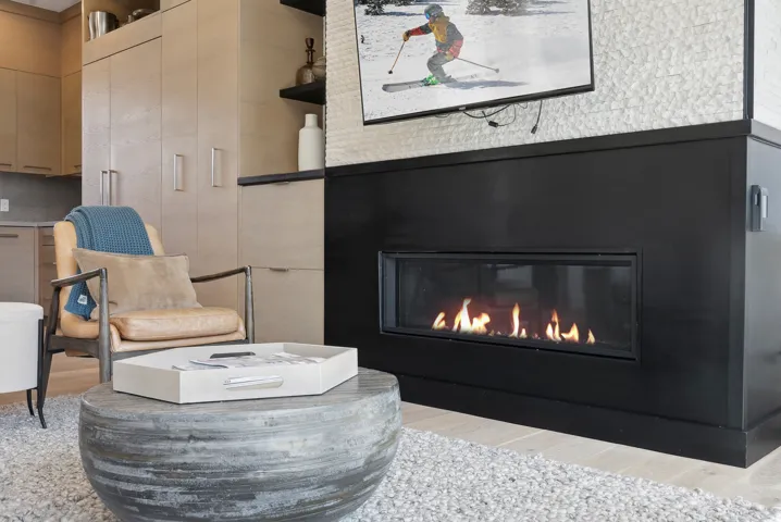 Sitting room featuring a glass covered fireplace and light wood finished floors