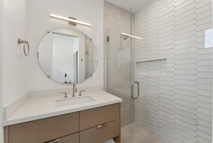 Full bath with a shower stall and vanity