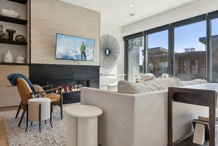 Living room with a glass covered fireplace, wood finished floors, and recessed lighting