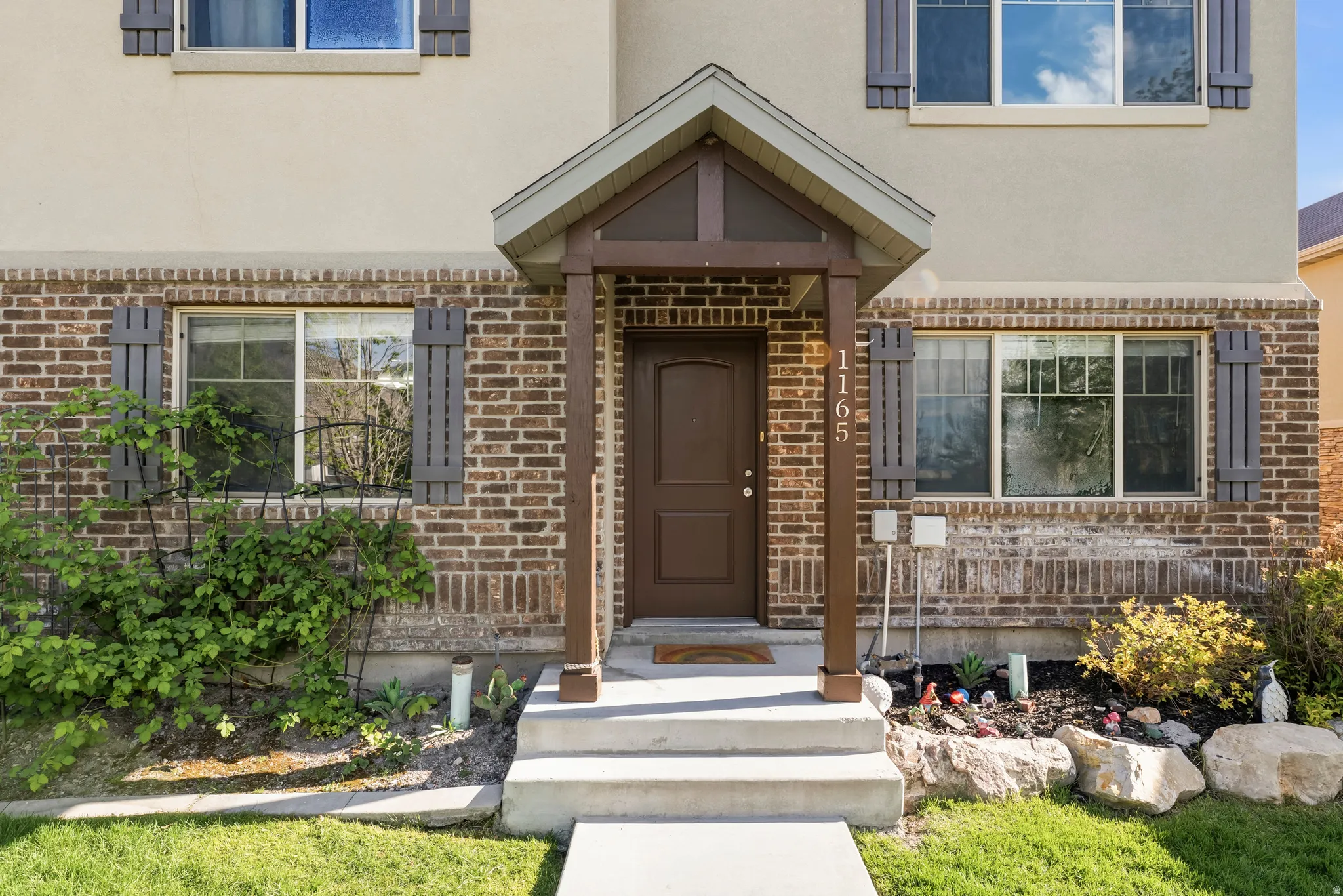 Doorway to property with stucco siding and brick siding