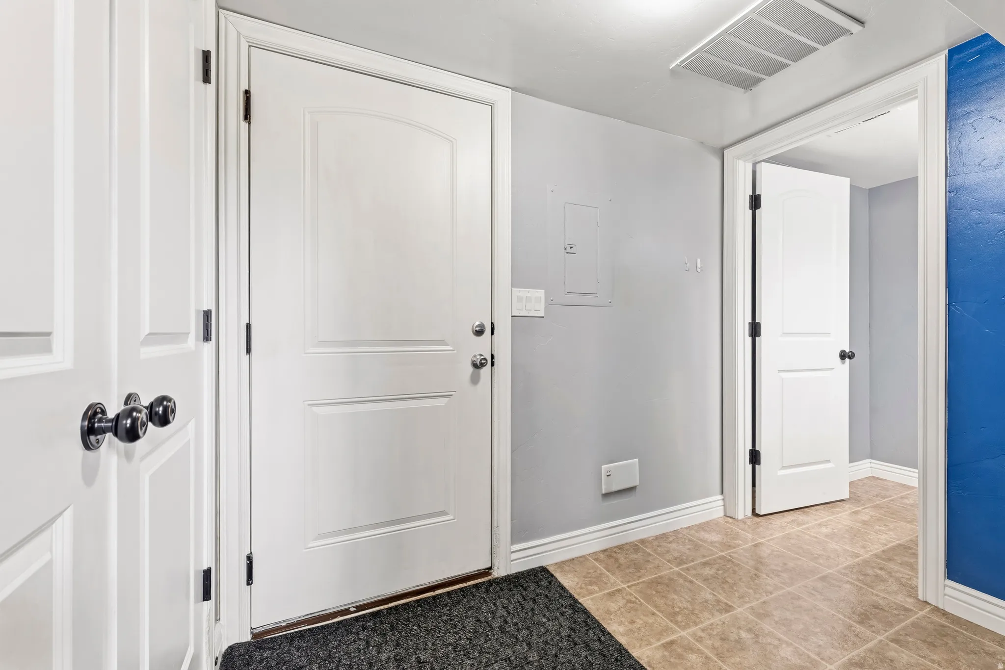 Entrance foyer with electric panel and light tile patterned floors