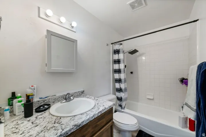 Full bathroom featuring vanity and shower / bathtub combination with curtain