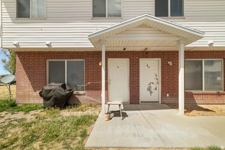 Property entrance with a porch and brick siding