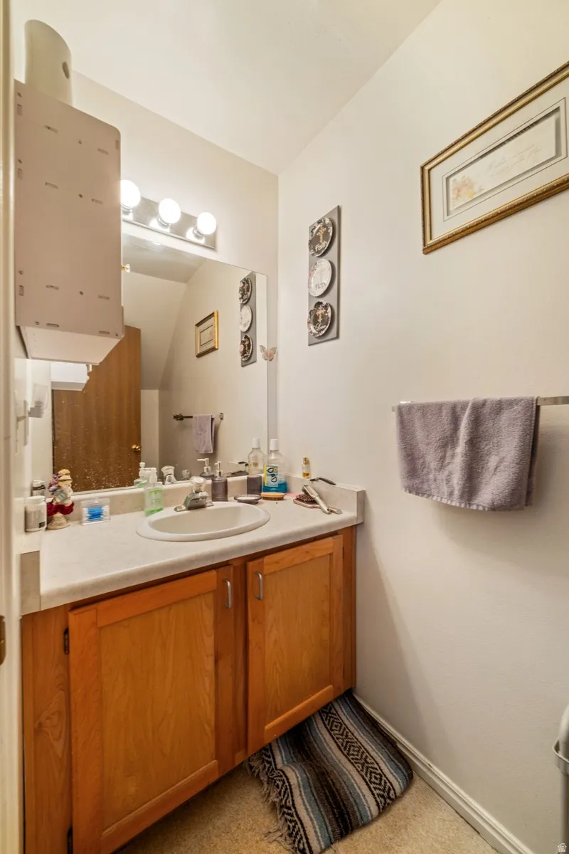 Bathroom featuring vanity and light carpet