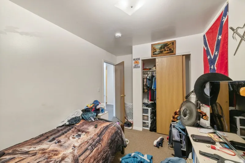 Bedroom featuring light carpet and a closet