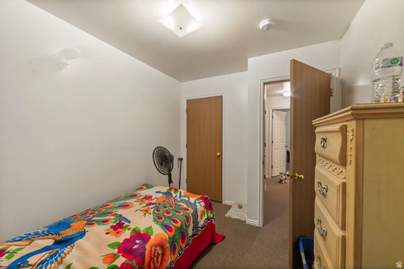 Bedroom with dark colored carpet and baseboards
